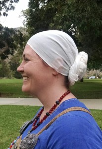 Knotted headscarf. In this style the scarf is wrapped around the head, and the tails are twisted together and coiled at the base of the neck.